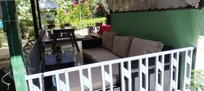 a living room with a couch on a balcony at Cabins yafeth osa drake bay in Drake