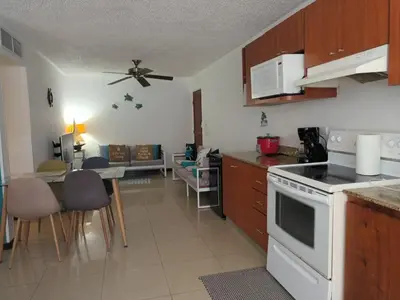 a kitchen with a white stove top oven next to a living room at 2Bed 2Bath Jaco Costa Linda in Jacó