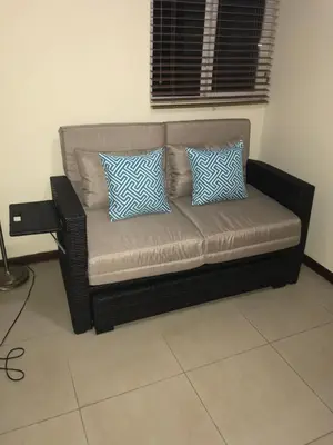 a brown couch with blue and white pillows in a room at 2Bed 2Bath Jaco Costa Linda in Jacó