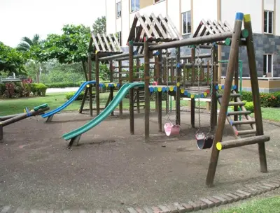 a playground with several swings and a slide at 2Bed 2Bath Jaco Costa Linda in Jacó