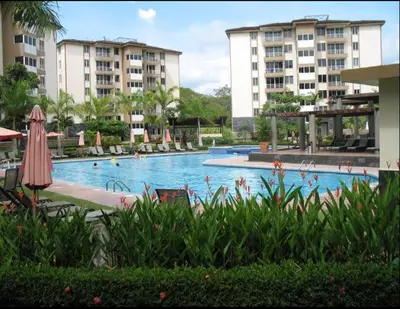 a large swimming pool in a resort with buildings at 2Bed 2Bath Jaco Costa Linda in Jacó