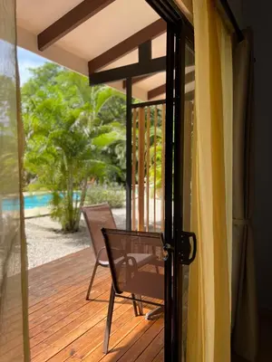 an open door to a deck with a chair at Surfside Mar Y Posa in Playa Flamingo