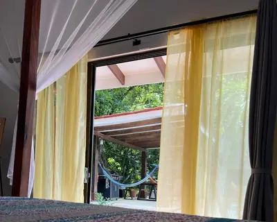 a bedroom with a window with curtains and a bed at Surfside Mar Y Posa in Playa Flamingo