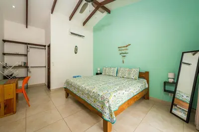 a bedroom with a bed and a table and a desk at Surfside Mar Y Posa in Playa Flamingo