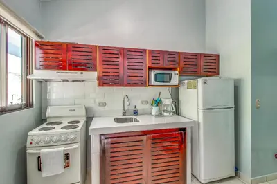 a kitchen with red cabinets and a white refrigerator at Aquamarine 4 in Guanacaste
