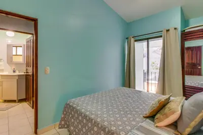 a bedroom with a bed and a door to a balcony at Aquamarine 4 in Guanacaste