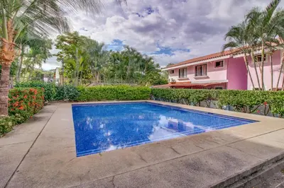 a swimming pool in a yard next to a house at Aquamarine 4 in Guanacaste