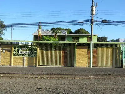 a building with a fence and a street at chez philippe in Orotina