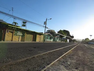 an empty street in a town with a building at chez philippe in Orotina