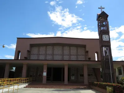 a building with a clock tower and a church at chez philippe in Orotina