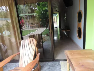 a room with a table and chairs and a sliding glass door at chez philippe in Orotina
