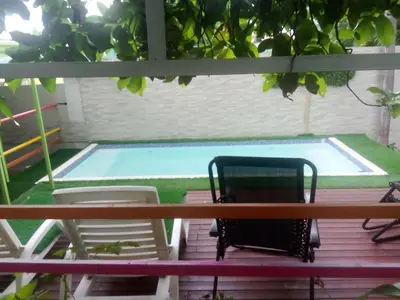 a deck with chairs and a swimming pool at chez philippe in Orotina