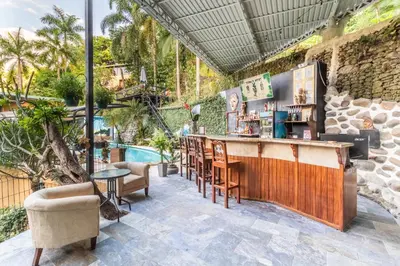 a bar on a patio next to a pool at Boutique Hotel Las Cascadas in Manuel Antonio