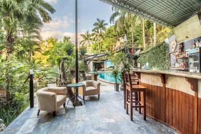 a bar on the patio of a resort with a pool at Boutique Hotel Las Cascadas in Manuel Antonio