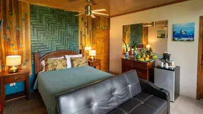 a bedroom with a bed and a couch at Boutique Hotel Las Cascadas in Manuel Antonio