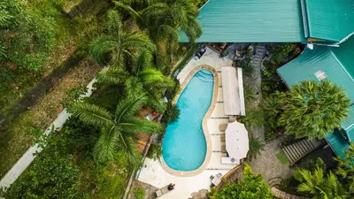 an overhead view of a swimming pool with palm trees at Boutique Hotel Las Cascadas in Manuel Antonio