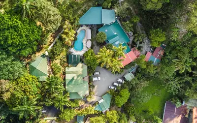 an overhead view of a house with a pool in the forest at Boutique Hotel Las Cascadas in Manuel Antonio