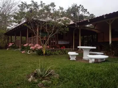 a house with two picnic tables in a yard at La Flor de Loto in Cartago
