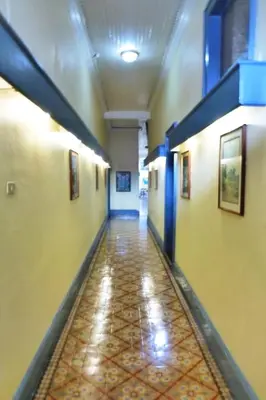 a hallway in a building with yellow walls and a tile floor at Hotel Santo Tomas / Historical Property in San José