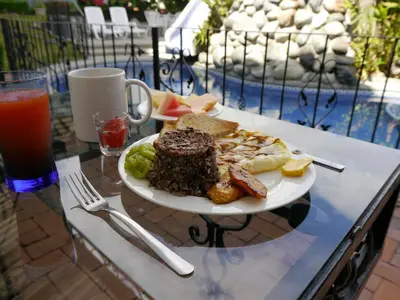 a plate of food on a table next to a drink at Hotel Santo Tomas / Historical Property in San José