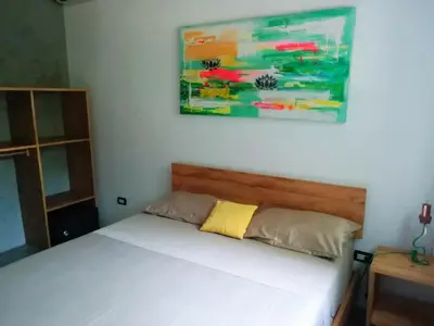 a bed in a bedroom with a painting on the wall at Shakti in Santa Teresa Beach