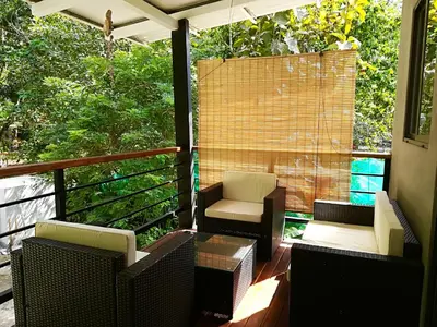 a porch with a chair and a table and chairs at Shakti in Santa Teresa Beach