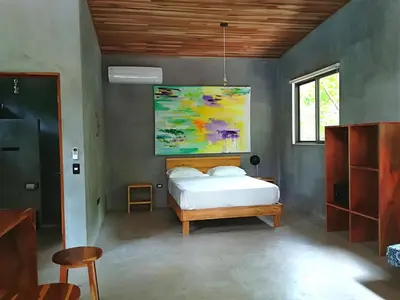a bedroom with a bed and a painting on the wall at Shakti in Santa Teresa Beach