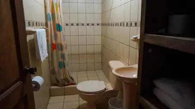 a small bathroom with a toilet and a sink at Hospedaje La Naciente in Turrialba