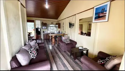 a living room with purple couches and a kitchen at Casa en zona tranquila y rural in Higueronal