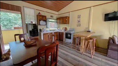 a kitchen with a wooden table and a dining room at Casa en zona tranquila y rural in Higueronal