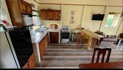 a kitchen with a stove and a table in it at Casa en zona tranquila y rural in Higueronal