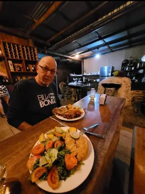 a man sitting at a table with a plate of food at EYA Ecolodge in San Isidro