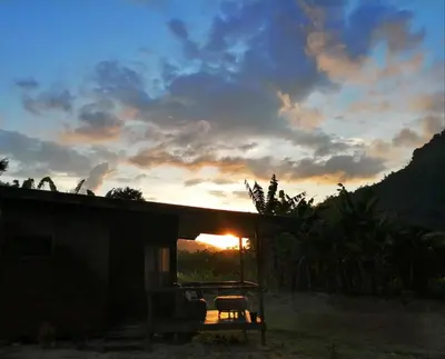 a house with a table and a chair at sunset at EYA Ecolodge in San Isidro