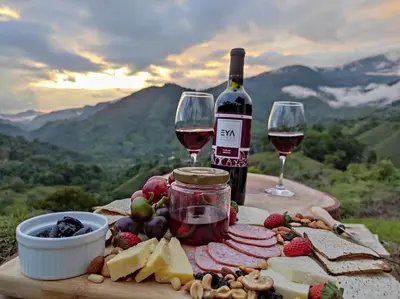 a table with wine and cheese and wine glasses at EYA Ecolodge in San Isidro