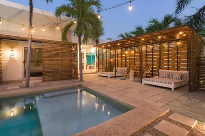 a house with a swimming pool next to a building at BOHO Tamarindo in Tamarindo