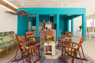 a living room with blue walls and wooden chairs at BOHO Tamarindo in Tamarindo