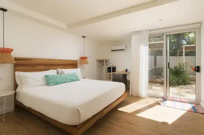 a bedroom with a large white bed and a window at BOHO Tamarindo in Tamarindo