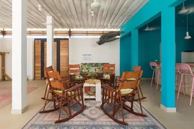 a table and chairs in a room with blue walls at BOHO Tamarindo in Tamarindo