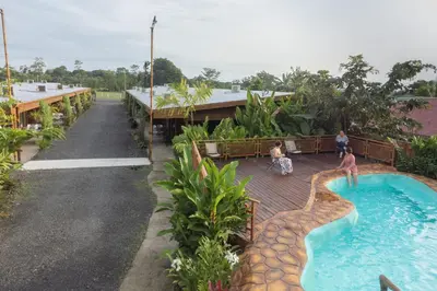 a pool at a resort with people playing in it at Cabañas del Rio in Fortuna