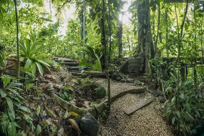 a path in the jungle with a statue in the middle at Cabañas del Rio in Fortuna