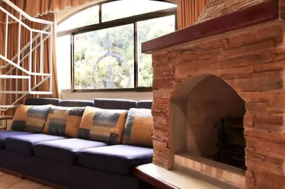 a couch in a living room with a brick fireplace at Hotel La Amistad in San José