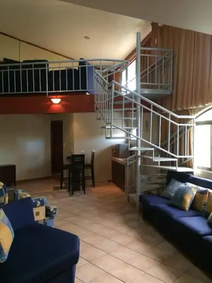 a living room with a spiral staircase and a couch at Hotel La Amistad in San José