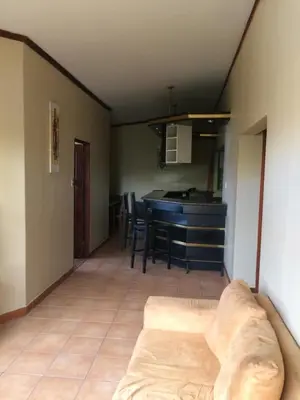a living room with a couch and a kitchen at Hotel La Amistad in San José