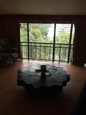 a living room with a coffee table and a balcony at Hotel La Amistad in San José