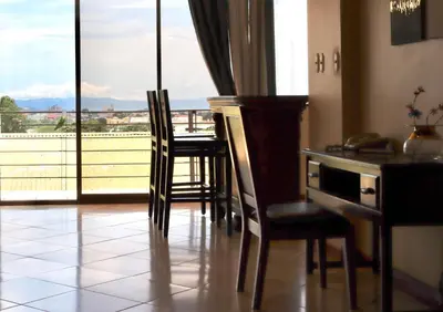 a kitchen with a table and chairs and a balcony at Hotel La Amistad in San José