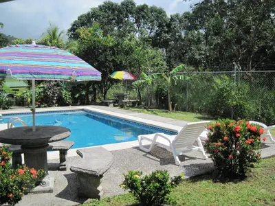 a pool with a table and an umbrella and a table and chairs at Chalet Villa Vilma in San Mateo