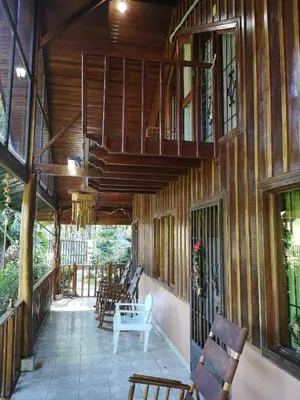 a porch of a house with wooden walls and chairs at Chalet Villa Vilma in San Mateo