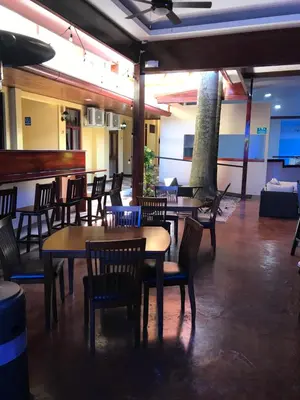a restaurant with tables and chairs and a bar at Hotel Castillo in San José