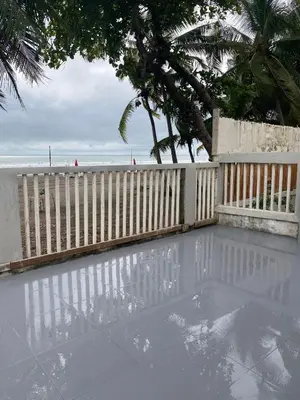 a swimming pool next to a fence and a beach at Gallina E Palo Beachfront Hotel in Jacó