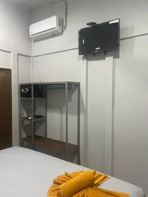 a room with a bed with a television and a bedskirtspectspects at Gallina E Palo Beachfront Hotel in Jacó